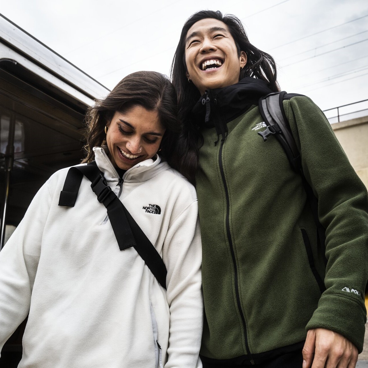 A couple wearing a quarter zip fleece and full zip fleece.,