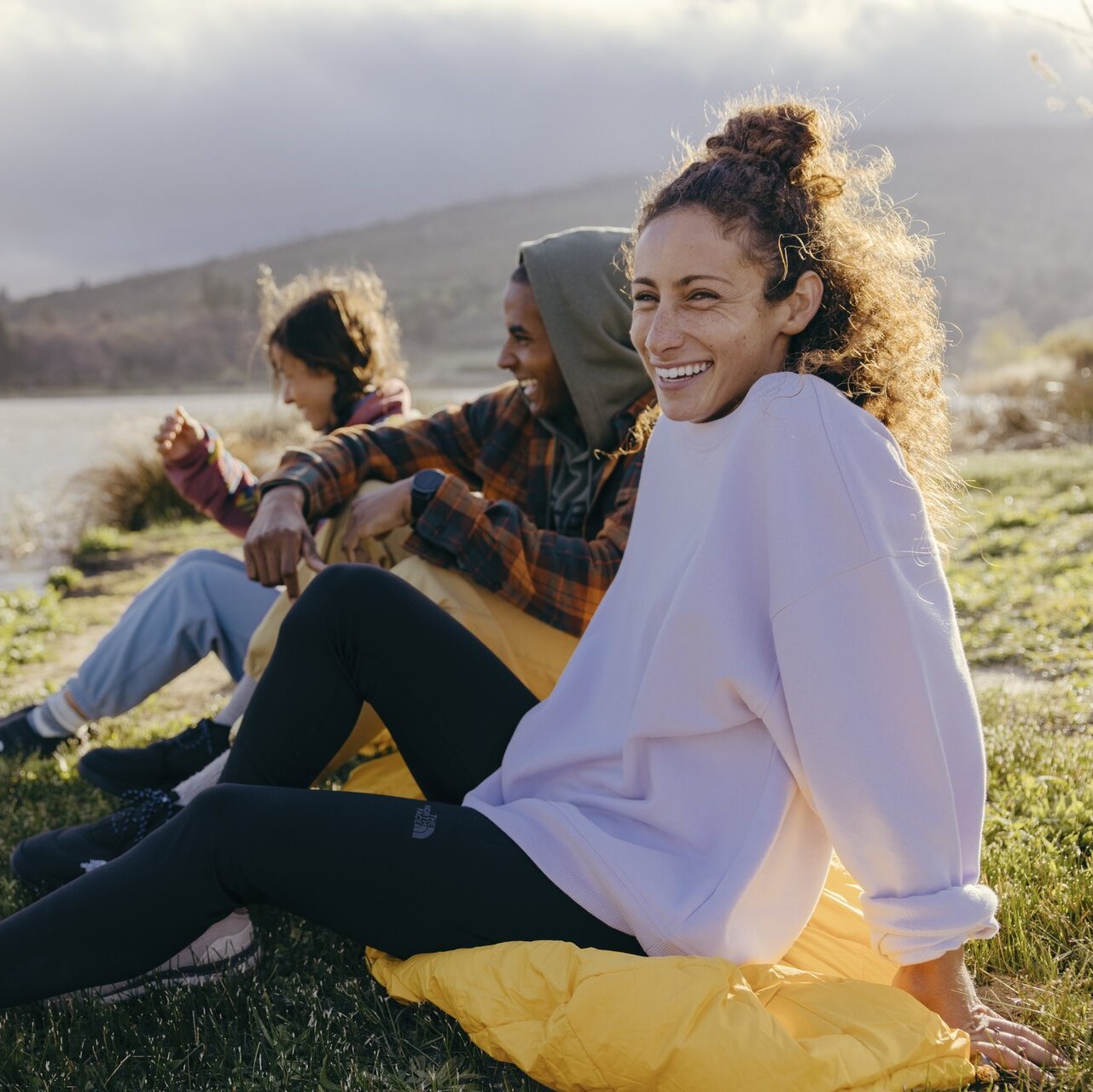 A girl wearing a crewneck sweatshirt and smiling.
