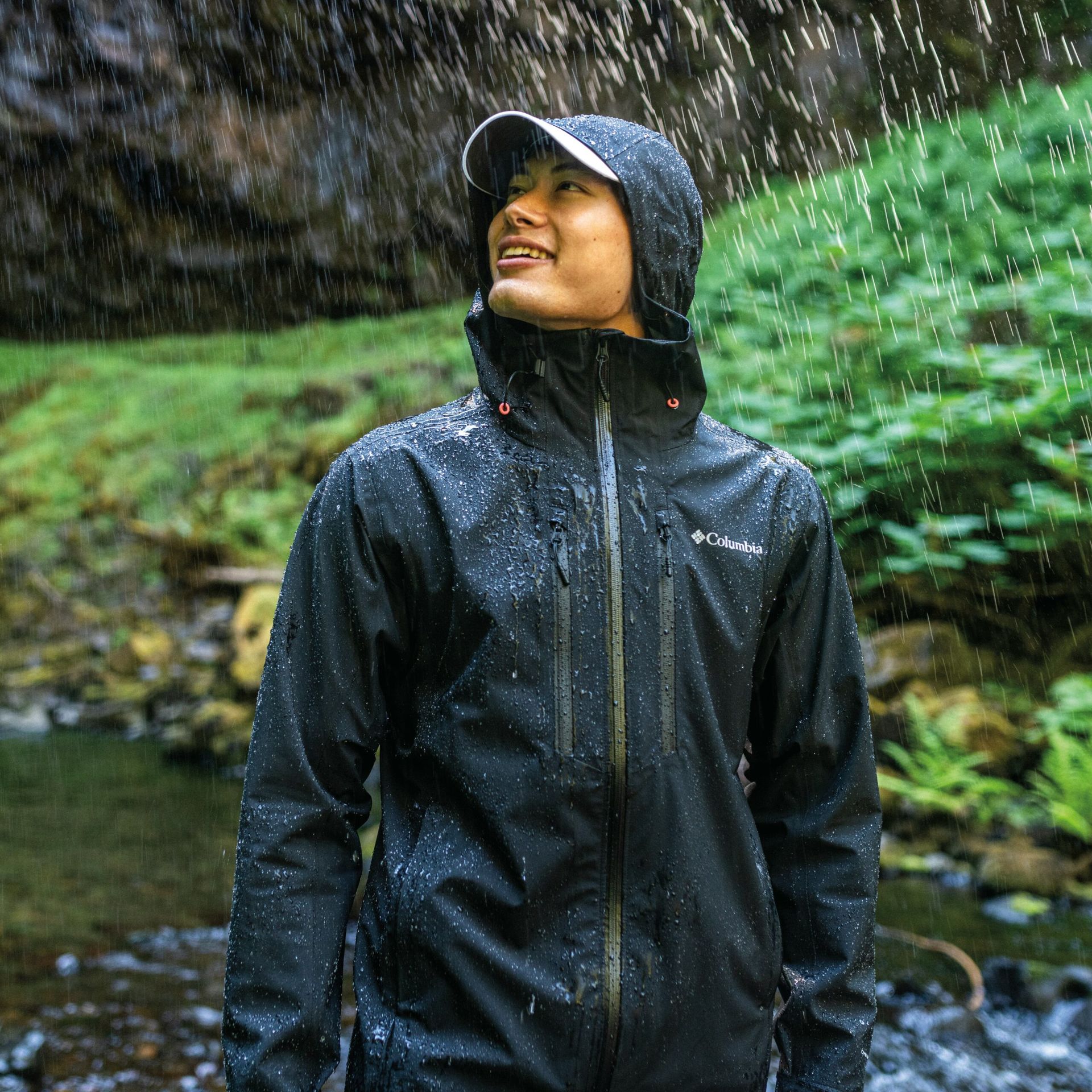 A man wearing a raincoat on a hike.