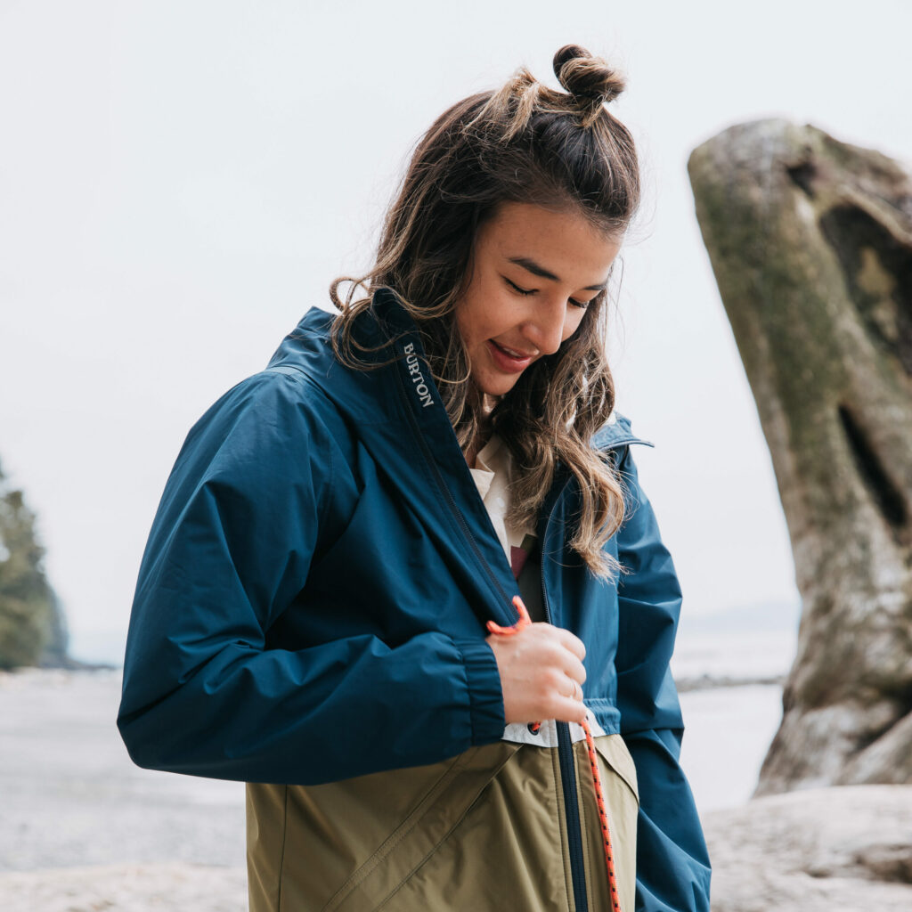 A woman putting on a winter jacket to stay warm.