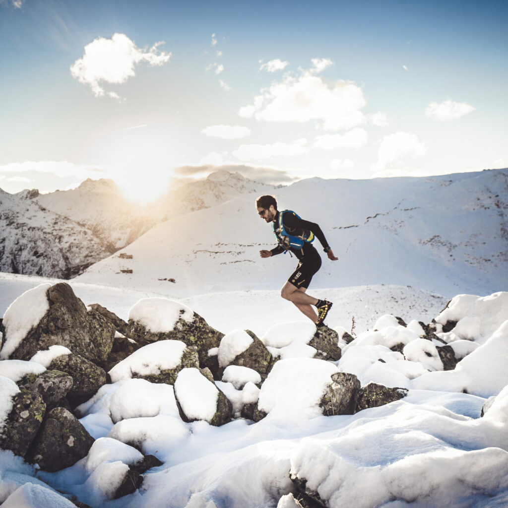 A runner on snow covered rocks.