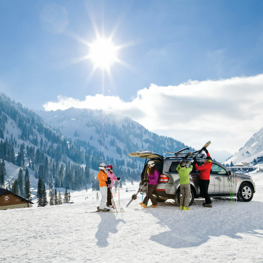 A family taking their gear off their vehicle with Thule bars.