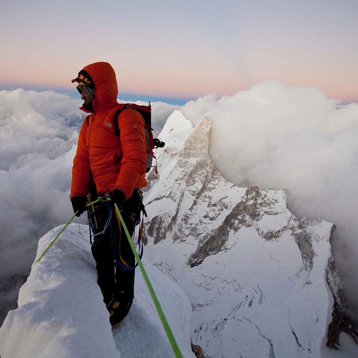 A climber in North Face Gear on top of a mountain in India.