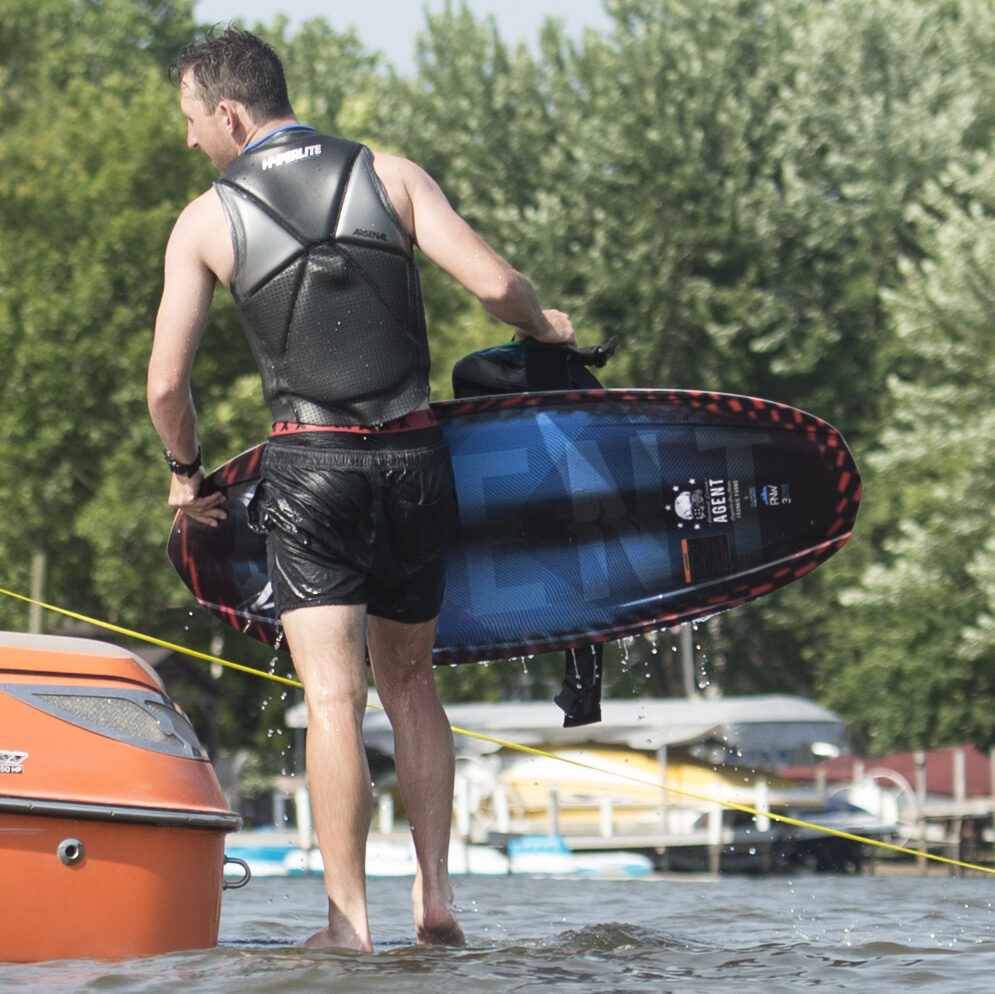 A professional kneeboarder carrying the HO Sports Agent kneeboard on a boat platform.