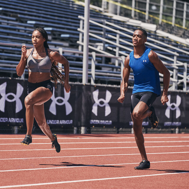 Two runners on a track wearing Under Armour running gear.