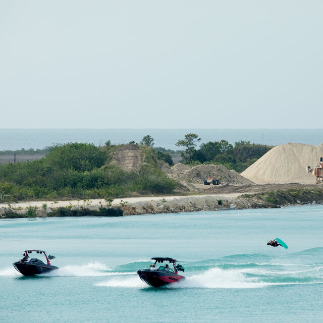 Overhead shot of a boat towing a wakeboarder.
