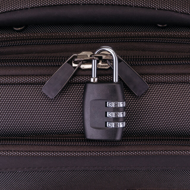 Number combination padlock on the gray suitcase.