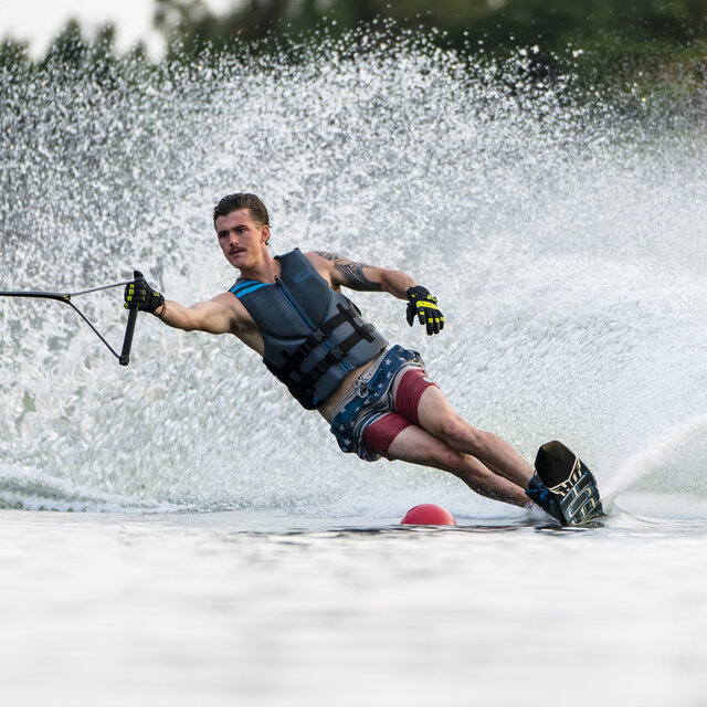 A man on an HO Sports Slalom Ski, going around a buoy.