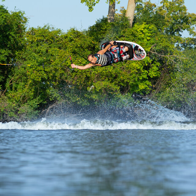 A male kneeboarder catching some air on an HO Sports kneeboard.