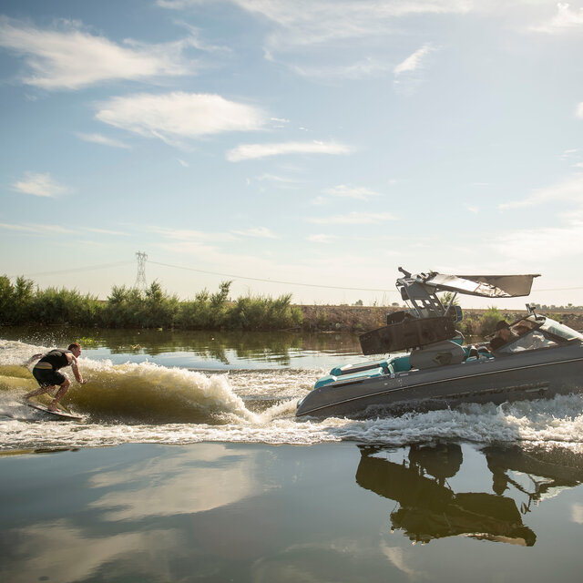 A boat creating a wake for a man on a Hyperlite Wakesurf Board