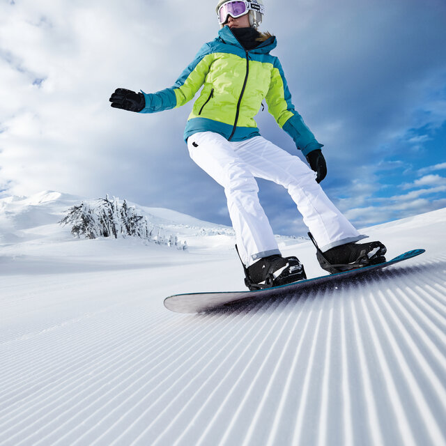 Snowboarding down some groomed slopes.