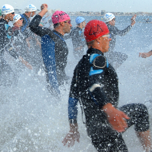 Racers taking off for the swim portion of a triathlon.