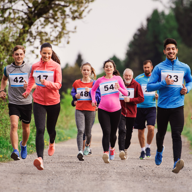 A group of runners smiling as they have fun during a run.