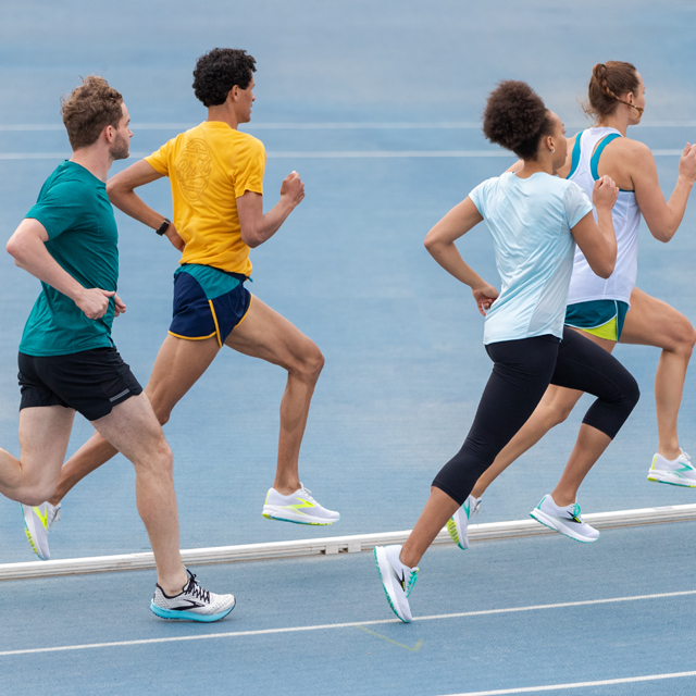 A group of runners on a blue track.