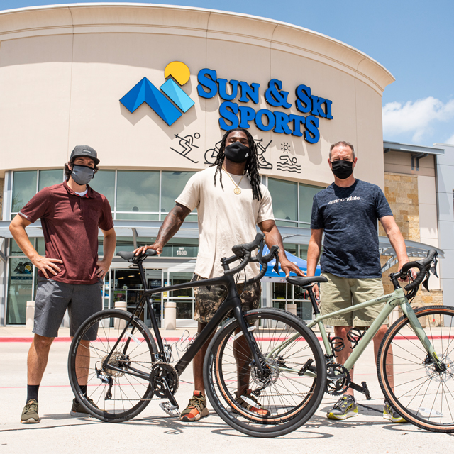 Jaylon Smith with his new Cannondale outside a Sun & Ski Sports with two employees.