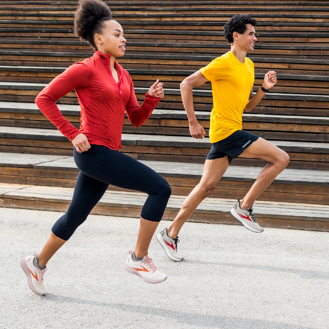 A pair of runners running next to some steps.