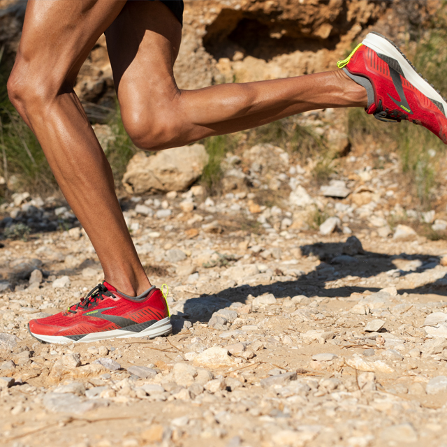 A runner in full-stride over gravel.