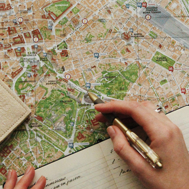 Hands making notes on a map with a pen.