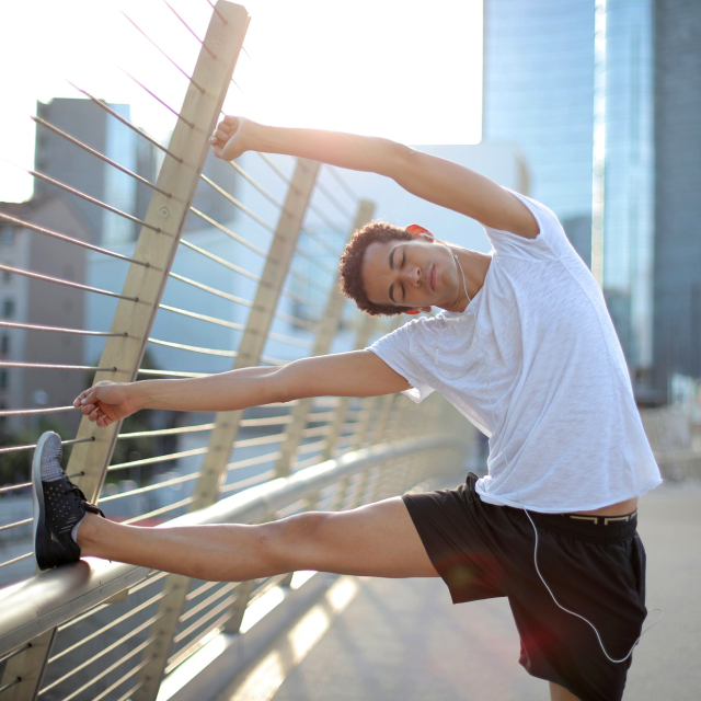 Man stretching core and legs on a bridge.