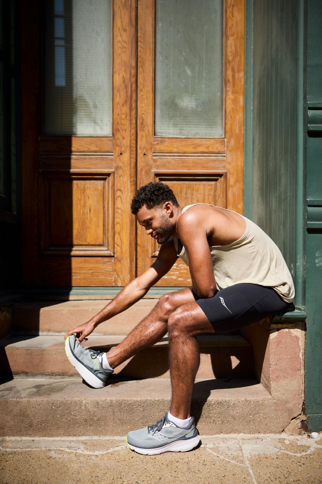 man stretching in running shoes