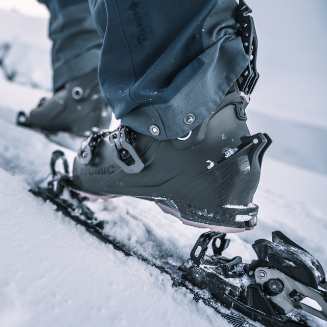 Someone putting on their skis.