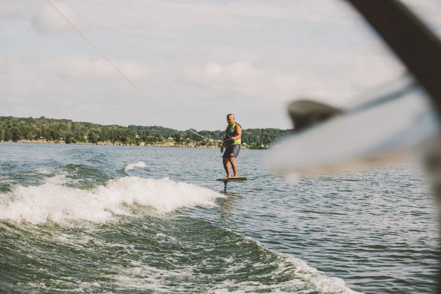 Man in life vest wake surfing