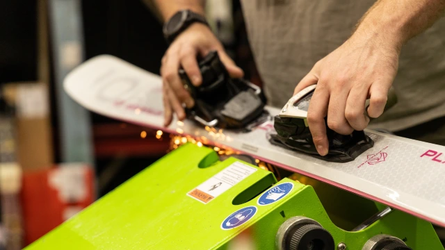 A ski shop expert tuning ski edges
