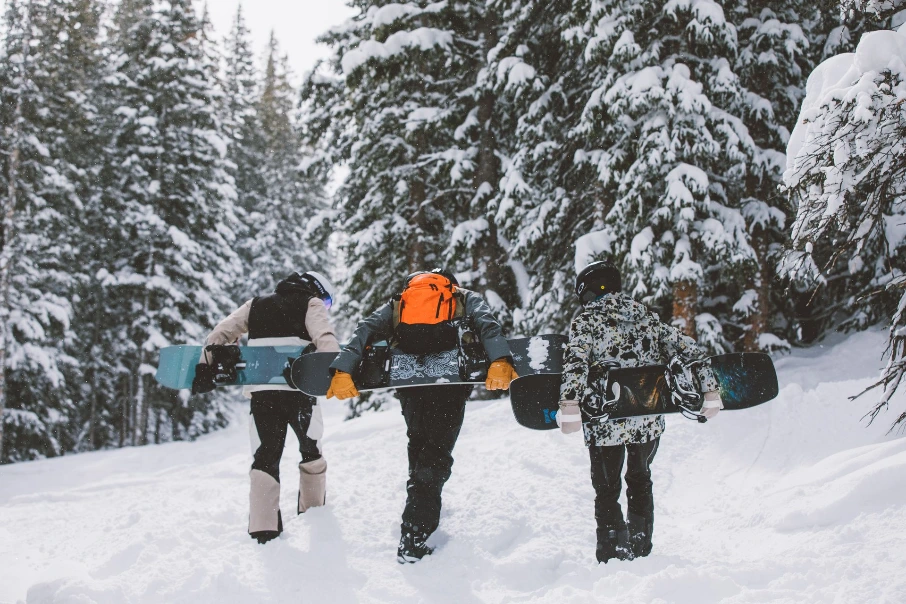 A group of riders carrying their snowboards to the top of the mountain